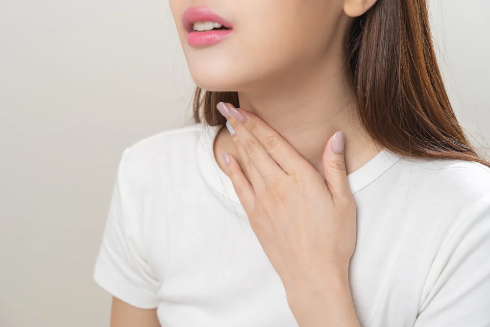 Woman experiencing persistent throat discomfort 